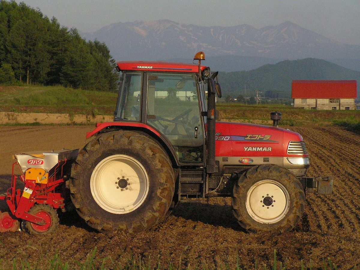 Yanmar compact tractor with a seeder working a field in Hokkaido, Japan